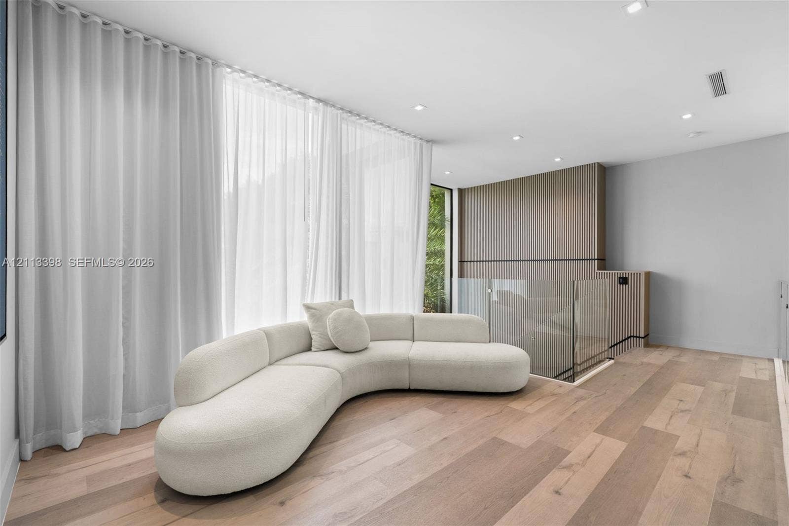 6814 NW 104th Court, #6814, Doral, Doral, FL 33178 Wood-finish flooring, floor-to-ceiling wall treatments, recessed ceiling lighting, and a glass-paneled railing