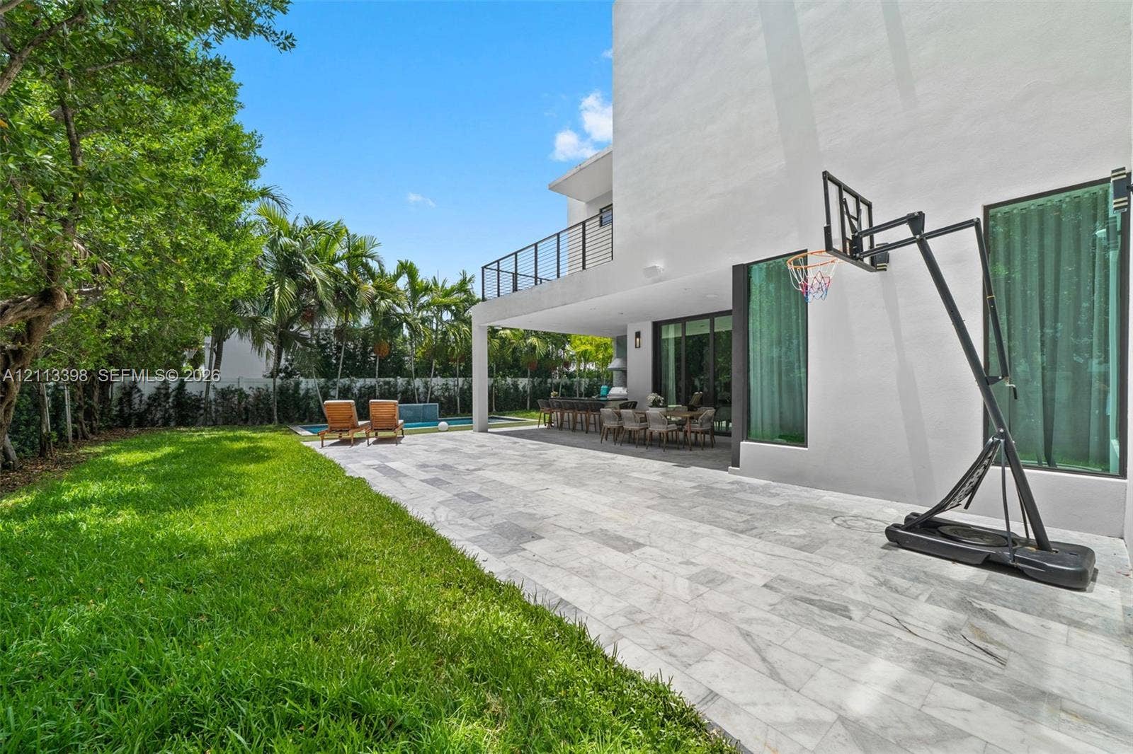 6814 NW 104th Court, #6814, Doral, Doral, FL 33178 Backyard featuring a paved stone patio, covered terrace, swimming pool, manicured lawn, and second-story balcony with metal railings