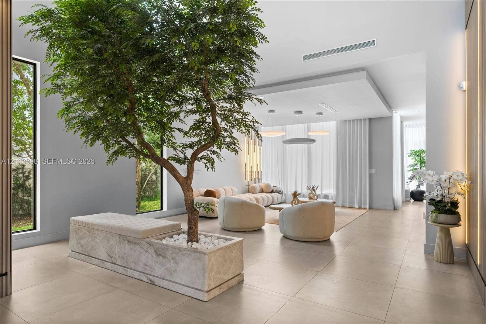 6814 NW 104th Court, #6814, Doral, Doral, FL 33178 Interior space featuring large-format tile flooring, a recessed ceiling with integrated lighting, floor-to-ceiling windows, and a built-in stone planter with an integrated bench