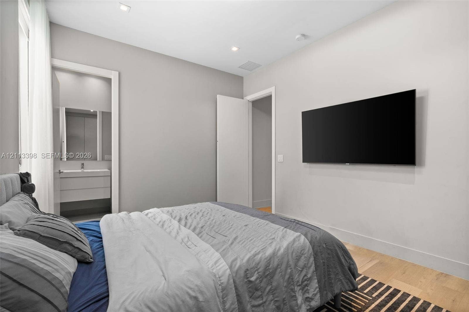 6814 NW 104th Court, #6814, Doral, Doral, FL 33178 Neutral-toned interior featuring recessed ceiling lighting, light-toned wood-finish flooring, and a wall-mounted display