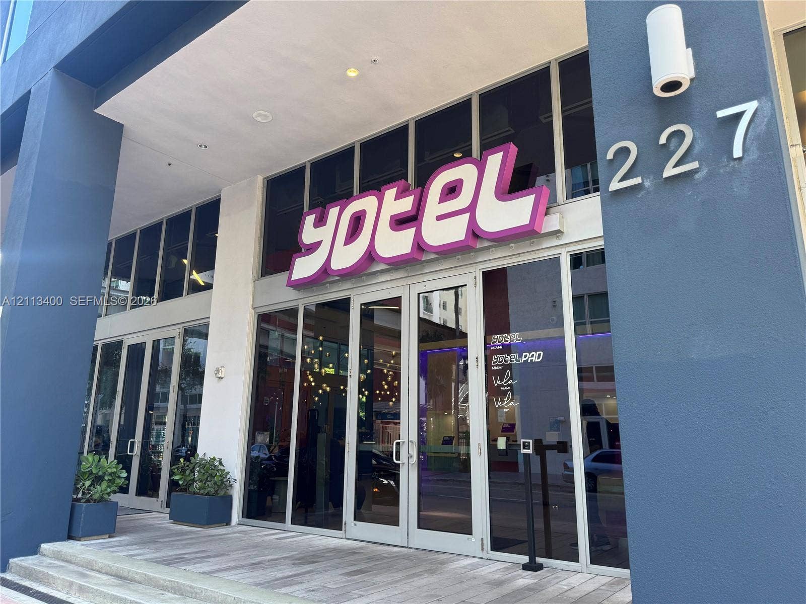 227 NE 2nd Street, #2105, Miami, FL 33132 Commercial storefront featuring floor-to-ceiling glass paneling, metal-framed doors, and high-contrast dark exterior finishes