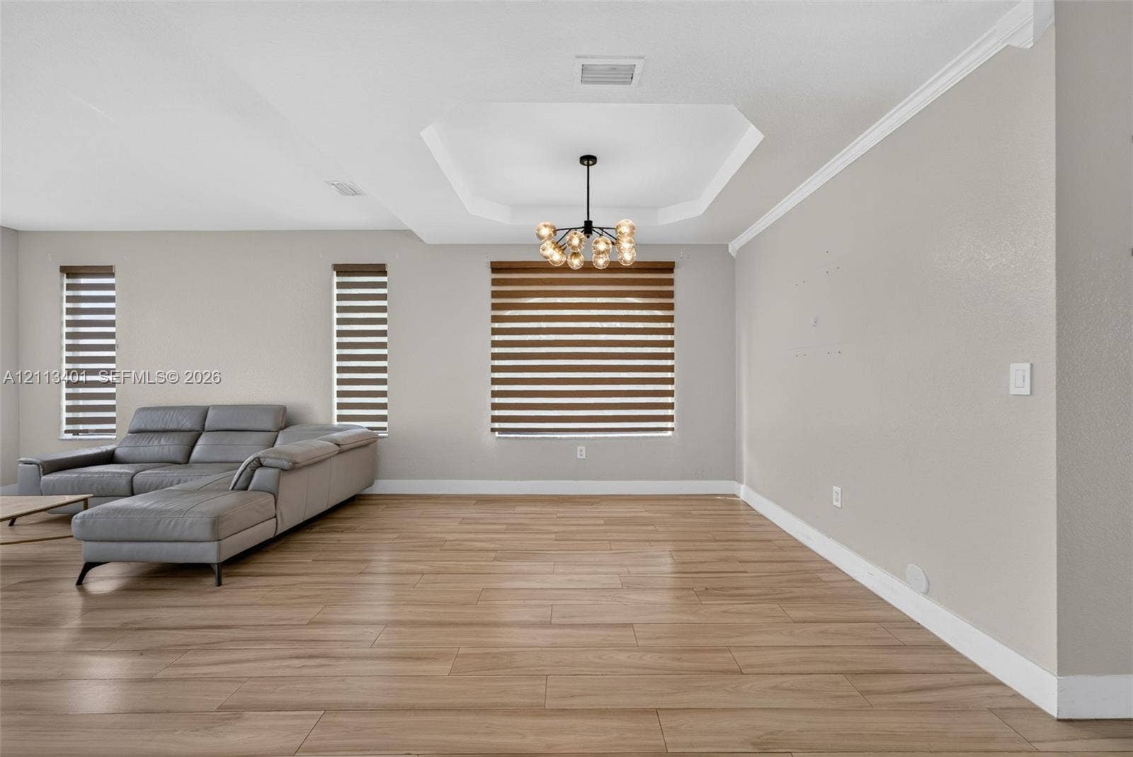 15891 SW 139th Street, Miami, Miami, FL 33196 Tray ceiling, multi-light modern chandelier, wood-finish flooring, and horizontal window shades
