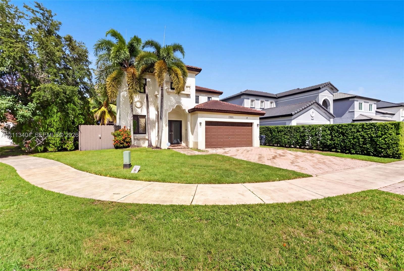 15891 SW 139th Street, Miami, Miami, FL 33196 Two-story exterior featuring a tile roof, stucco finish, arched entryway, and a paver driveway leading to an attached garage