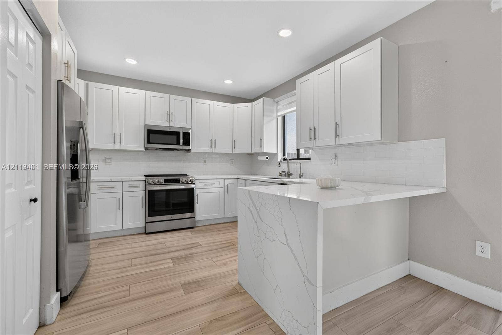 15891 SW 139th Street, Miami, Miami, FL 33196 Kitchen featuring white shaker-style cabinetry, a stone-patterned waterfall countertop, stainless steel appliances, and wood-finish flooring