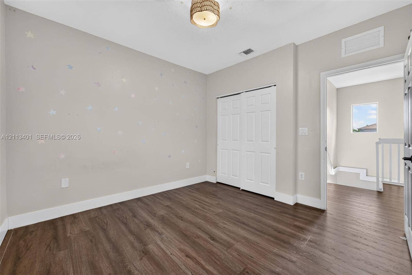 15891 SW 139th Street, Miami, Miami, FL 33196 Room featuring wood-finish flooring, a double-panel sliding closet, and a neutral-toned ceiling light fixture