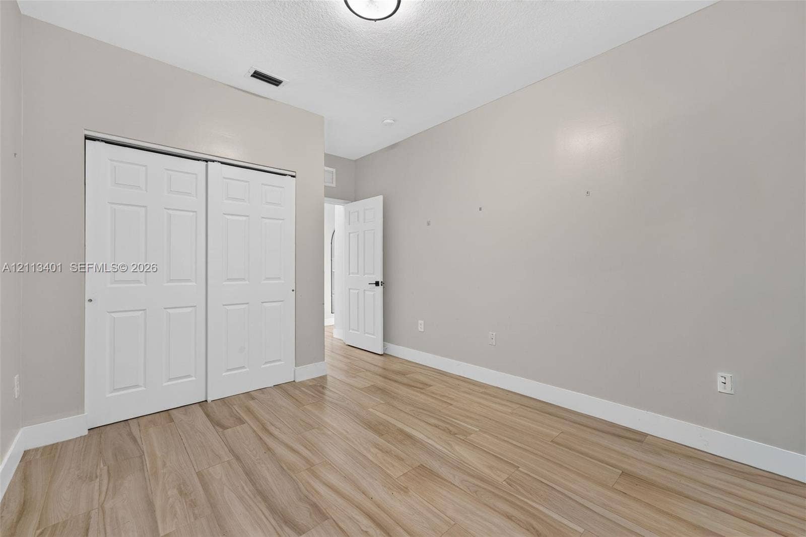 15891 SW 139th Street, Miami, Miami, FL 33196 Room featuring wood-finish flooring, neutral wall paint, and a sliding-door closet
