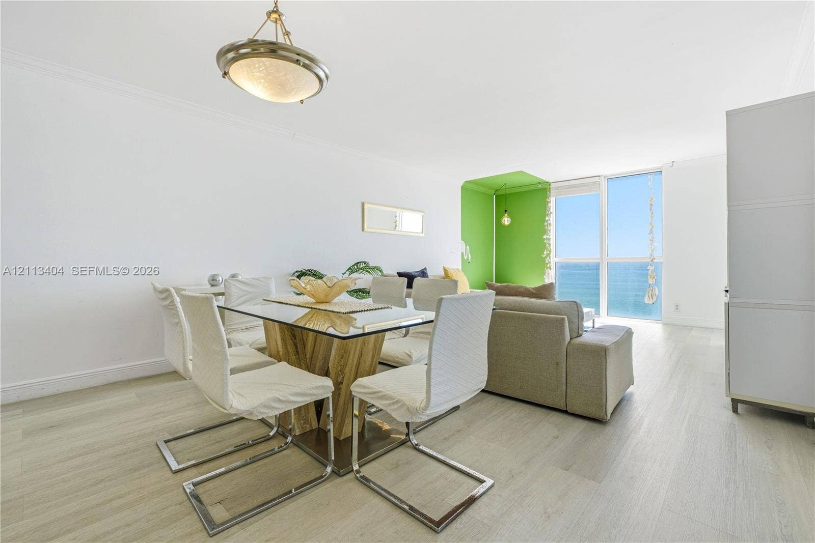 Living area featuring floor-to-ceiling windows, wood-finish flooring, and a decorative pendant light fixture