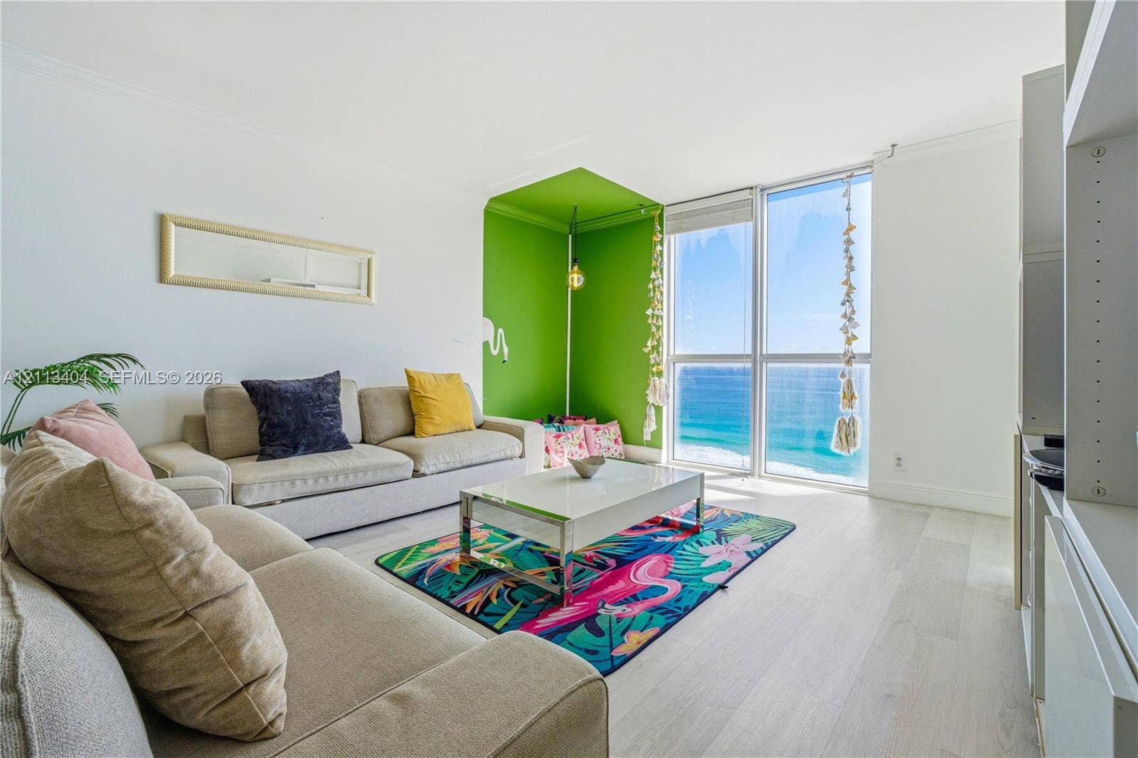 Floor-to-ceiling windows featuring ocean horizon, wood-finish flooring, and built-in shelving