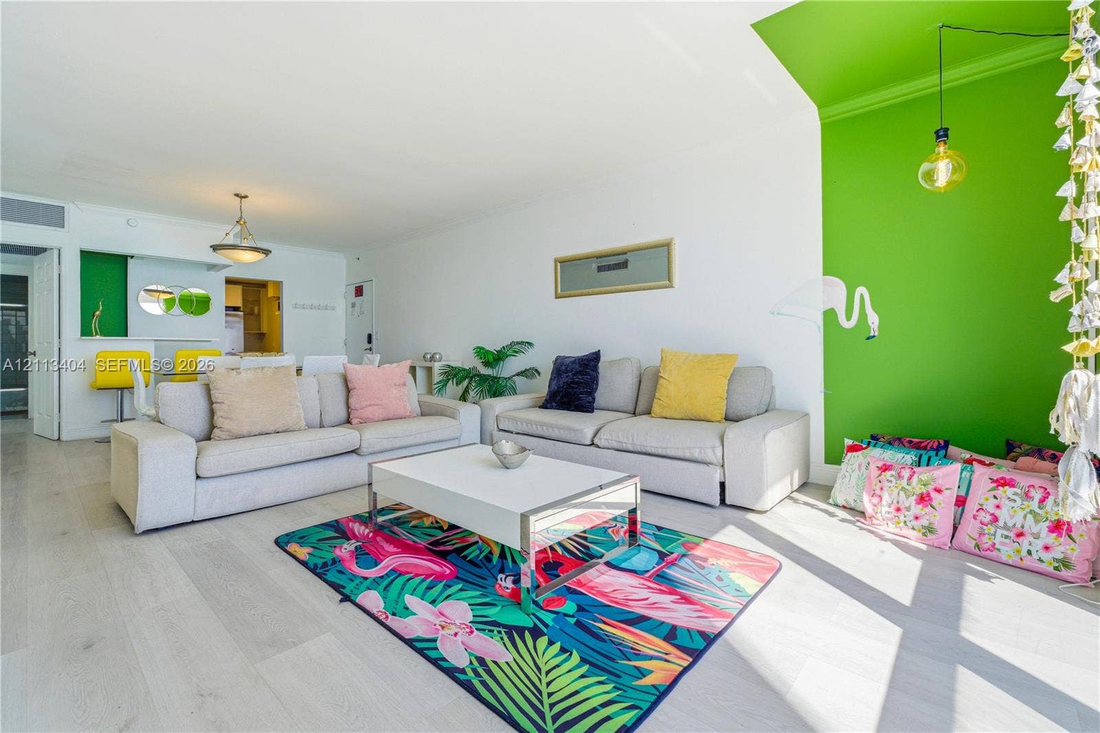 Living area featuring wood-finish flooring, vaulted ceilings, and a distinctive accent wall