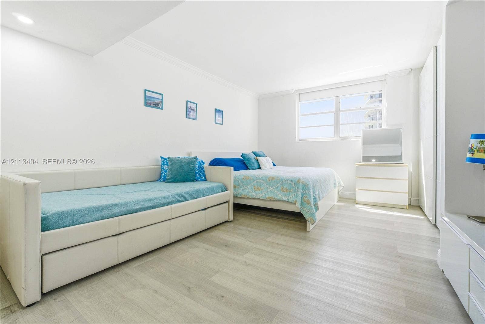 Bright room featuring wood-finish flooring, recessed lighting, and a large horizontal window