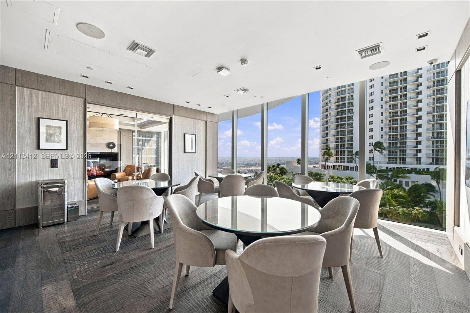 17475 Collins Avenue, #1802, Sunny Isles Beach, FL 33160 Floor-to-ceiling glass walls, wood-finish flooring, recessed lighting, and wall-mounted paneling