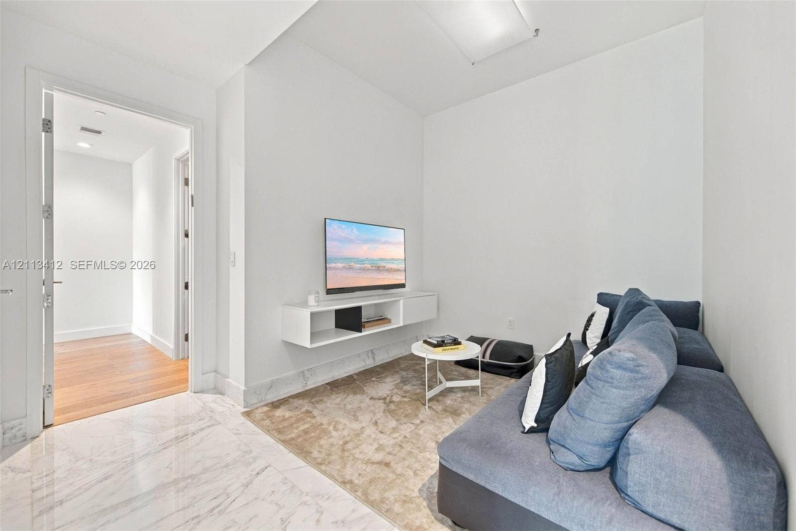 17475 Collins Avenue, #1802, Sunny Isles Beach, FL 33160 Polished stone flooring, wood-finish flooring, and wall-mounted white cabinetry