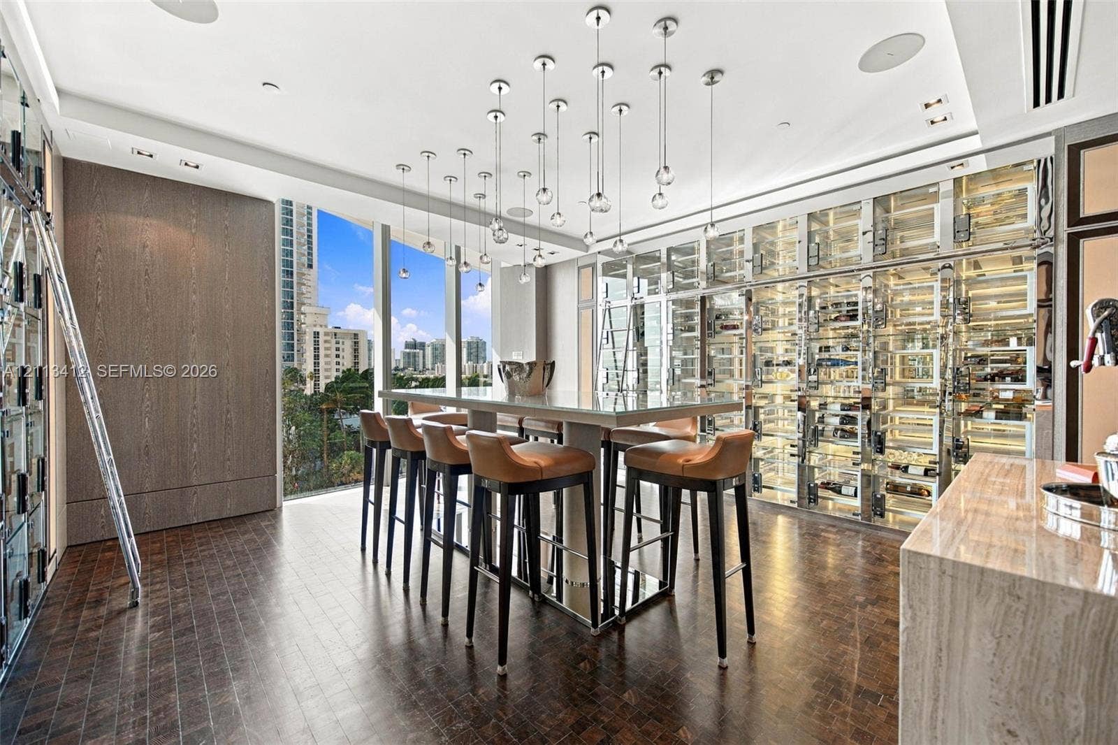 17475 Collins Avenue, #1802, Sunny Isles Beach, FL 33160 Custom temperature-controlled wine storage wall, floor-to-ceiling glass windows, wood-finish flooring, central island with quartz countertop, and multi-pendant lighting