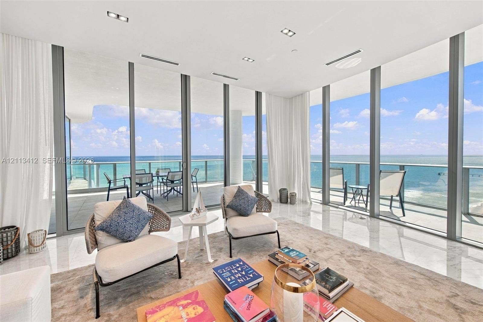 17475 Collins Avenue, #1802, Sunny Isles Beach, FL 33160 Floor-to-ceiling glass walls, expansive balcony, stone-finish flooring, recessed ceiling lighting, and horizontal ocean backdrop