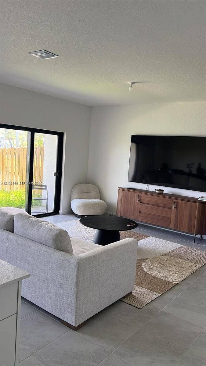 3024 Green Palm Court, #5838, Dania, Dania Beach, FL 33312 Interior space featuring large-format tile flooring, neutral wall finishes, and black-framed sliding glass doors