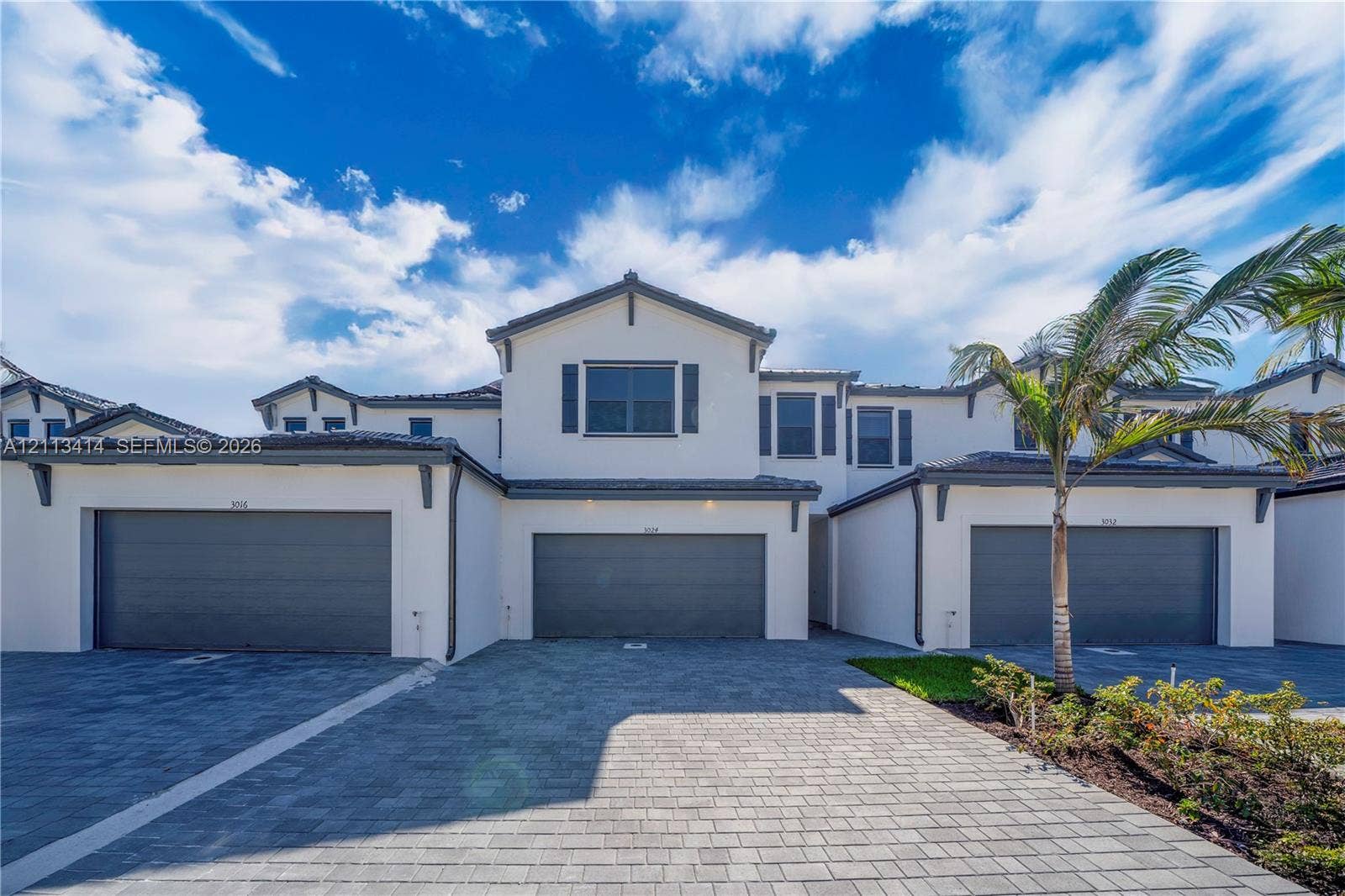 3024 Green Palm Court, #5838, Dania, Dania Beach, FL 33312 Multi-level stucco exterior featuring a tiled roof, grey-toned garage doors, and paver driveway