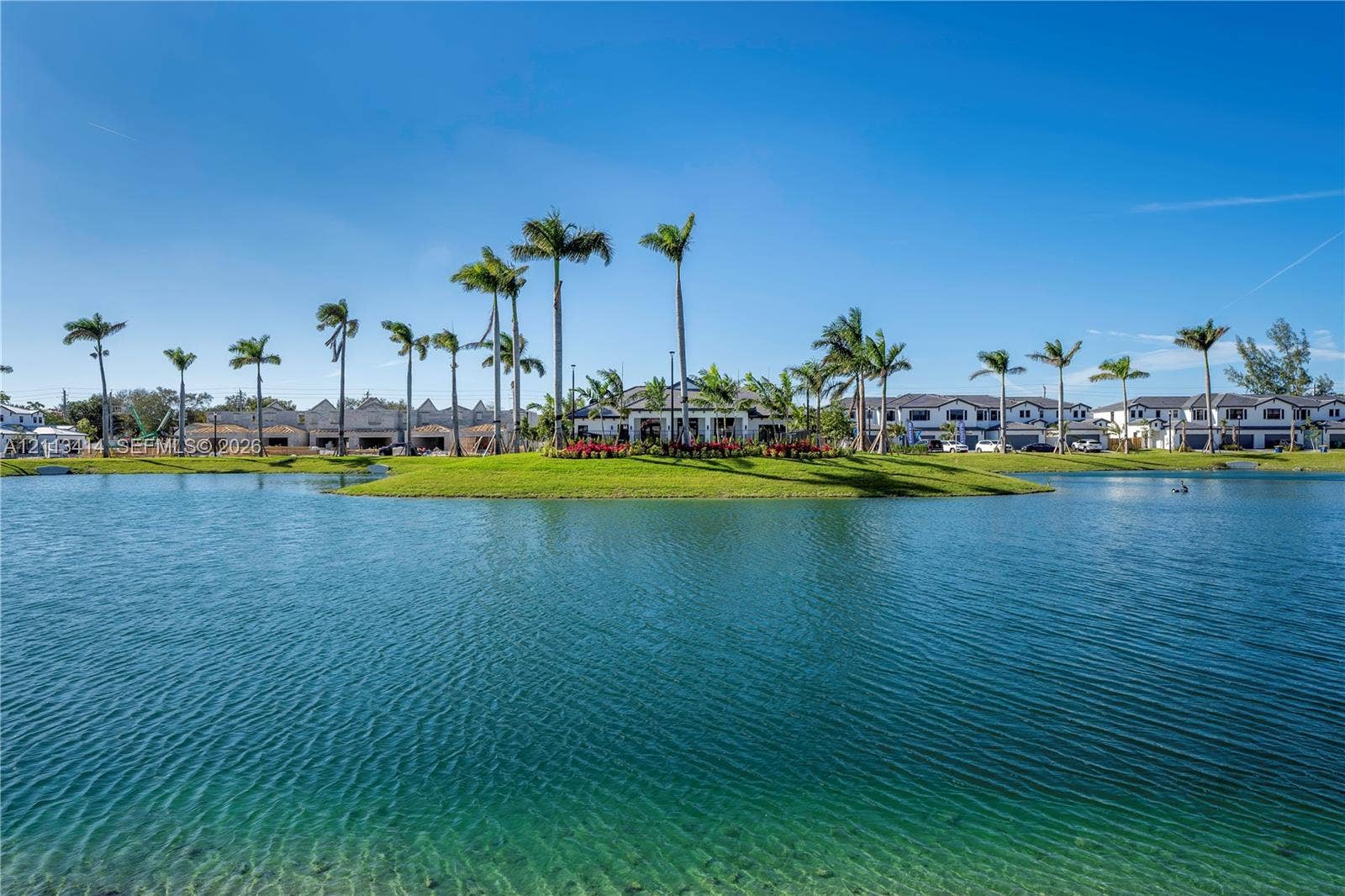 3024 Green Palm Court, #5838, Dania, Dania Beach, FL 33312 Expansive lakefront setting featuring a central island, manicured lawn, and mature palm trees