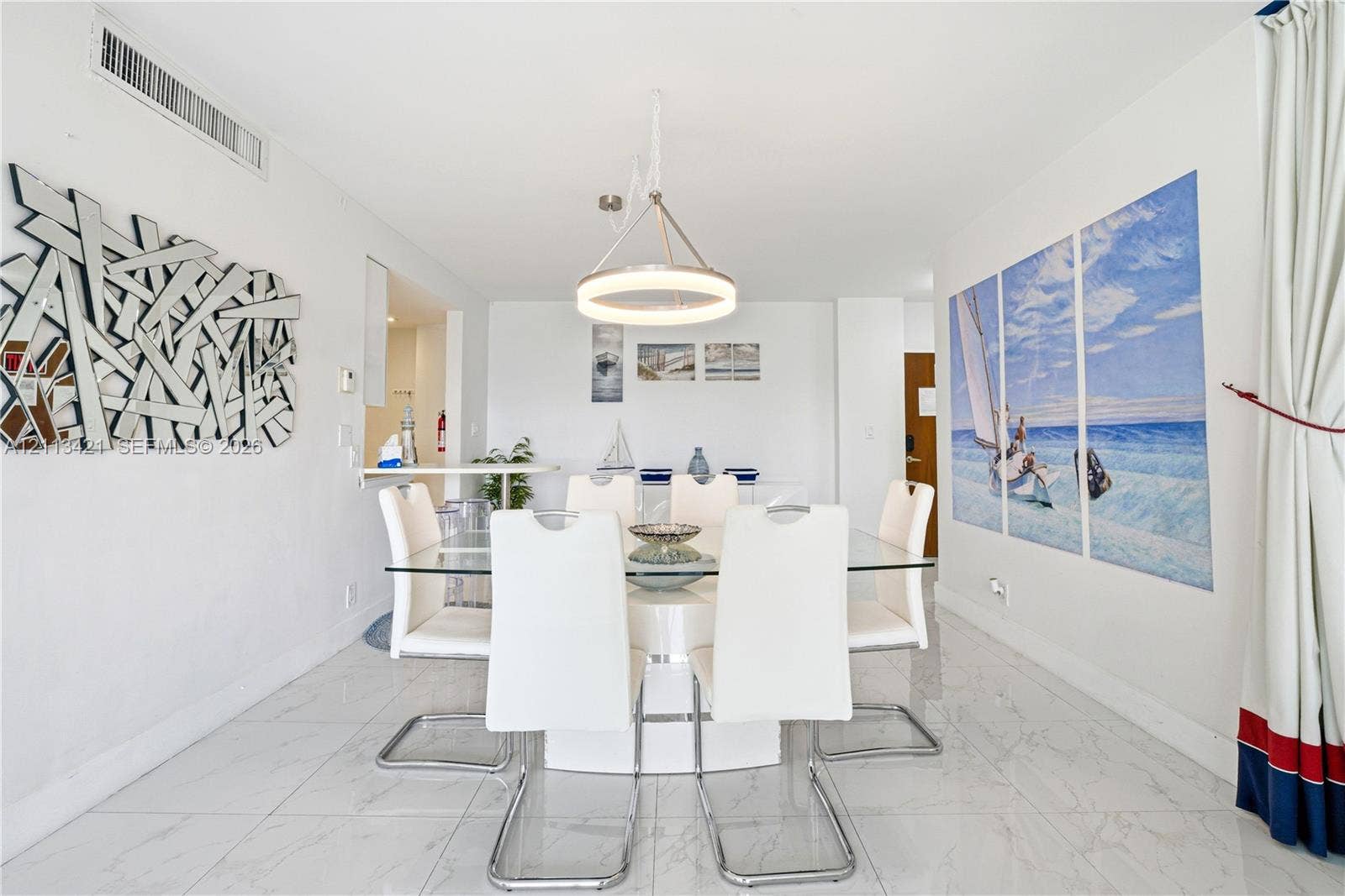 3901 S Ocean Drive, #5L, Hollywood, FL 33019 Dining area featuring polished stone-finish tile flooring, a circular tiered chandelier, and a built-in counter surface