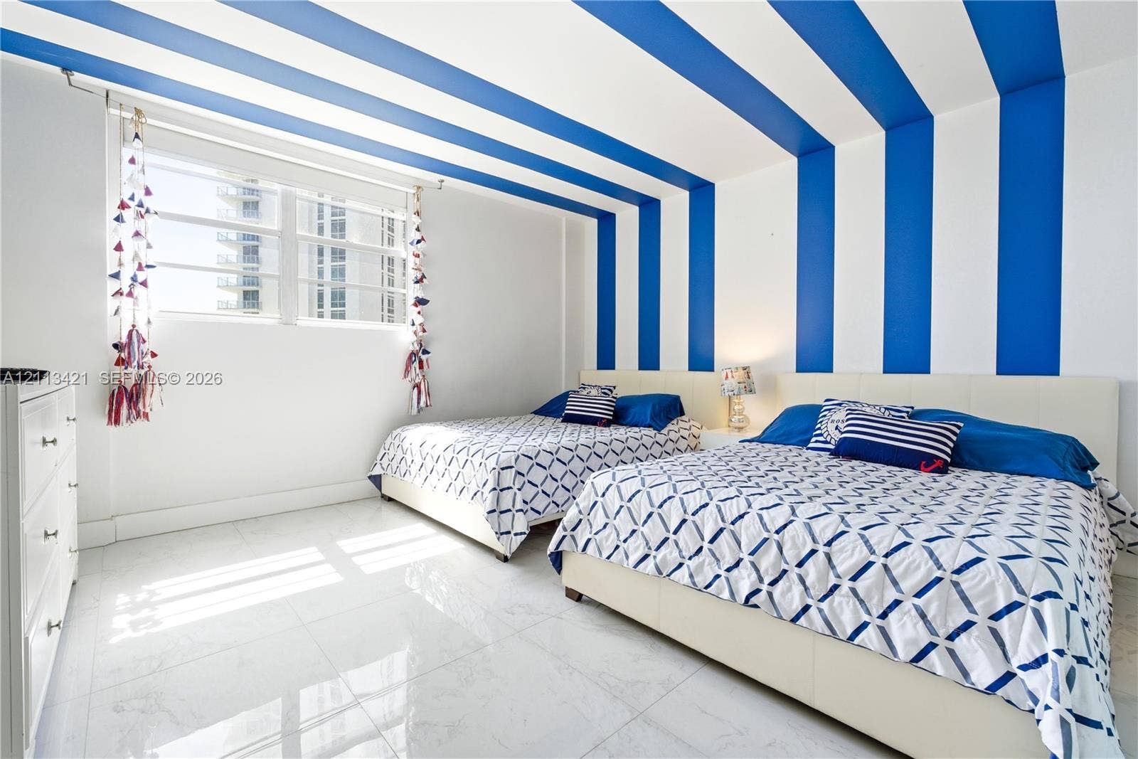 3901 S Ocean Drive, #5L, Hollywood, FL 33019 Room featuring large-format polished tile flooring, expansive multi-pane window, and distinctive wall-to-ceiling blue and white vertical accent stripes