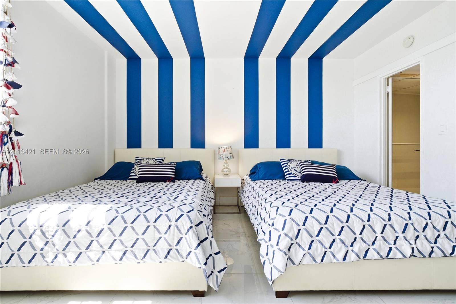 3901 S Ocean Drive, #5L, Hollywood, FL 33019 Room featuring high-contrast blue and white vertical wall and ceiling stripes, polished tile flooring, and a recessed doorway
