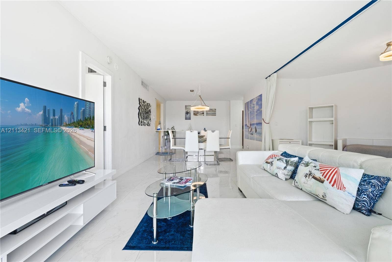 3901 S Ocean Drive, #5L, Hollywood, FL 33019 Open-concept interior featuring large-format tile flooring, recessed lighting, and a white built-in media console