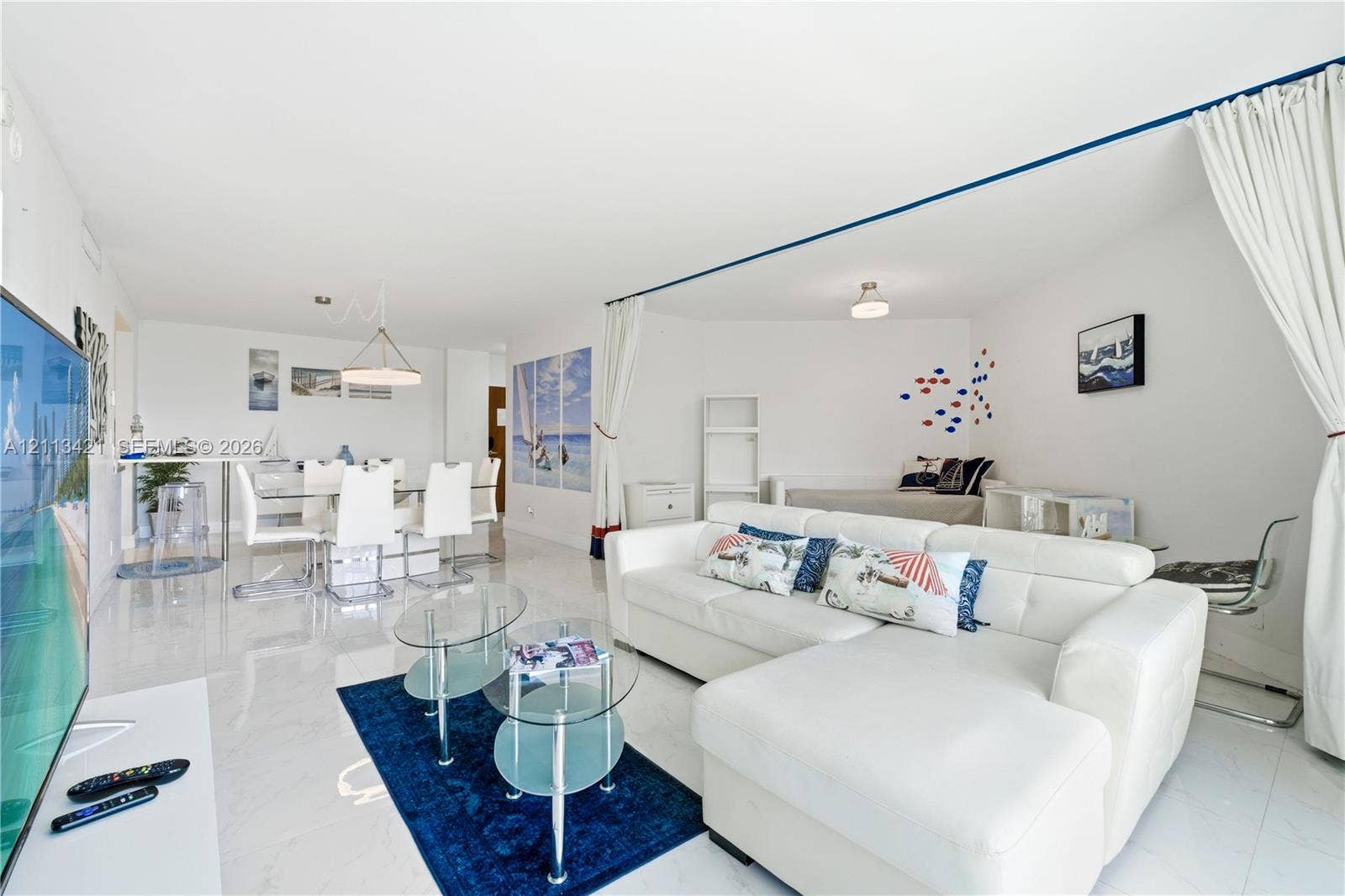3901 S Ocean Drive, #5L, Hollywood, FL 33019 Open-concept interior featuring large-format tile flooring, recessed ceiling lighting, and a geometric pendant light fixture