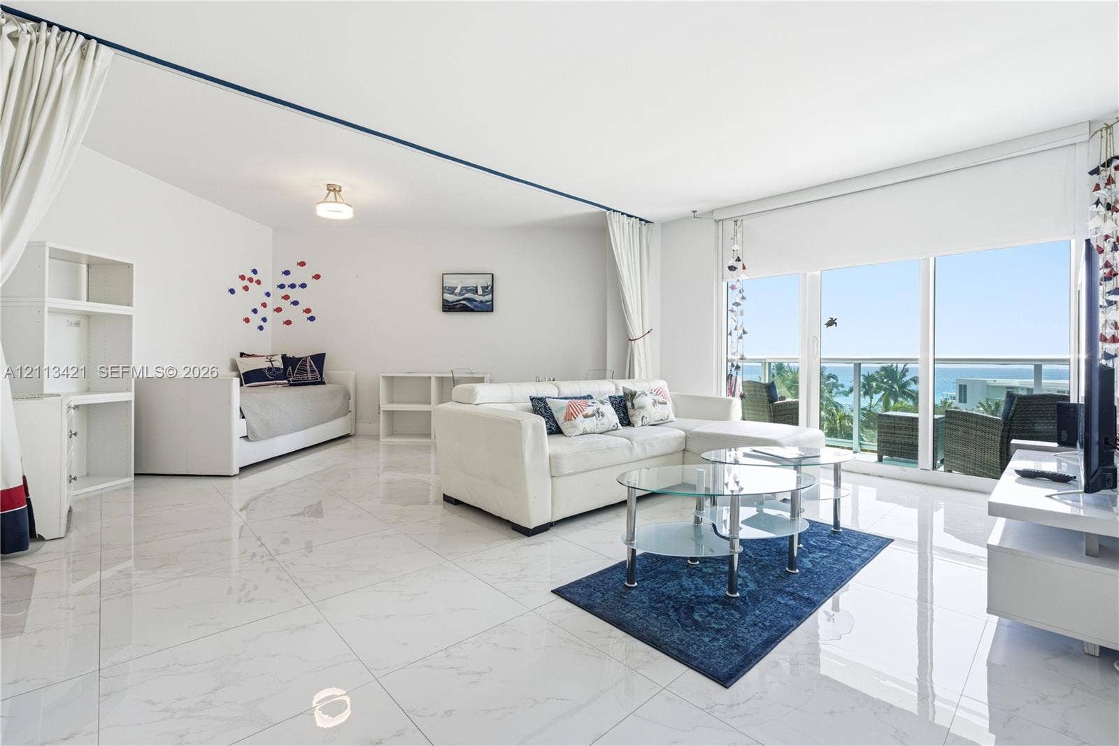 3901 S Ocean Drive, #5L, Hollywood, FL 33019 Large-format white tile flooring, floor-to-ceiling sliding glass doors, and a private balcony featuring a glass railing