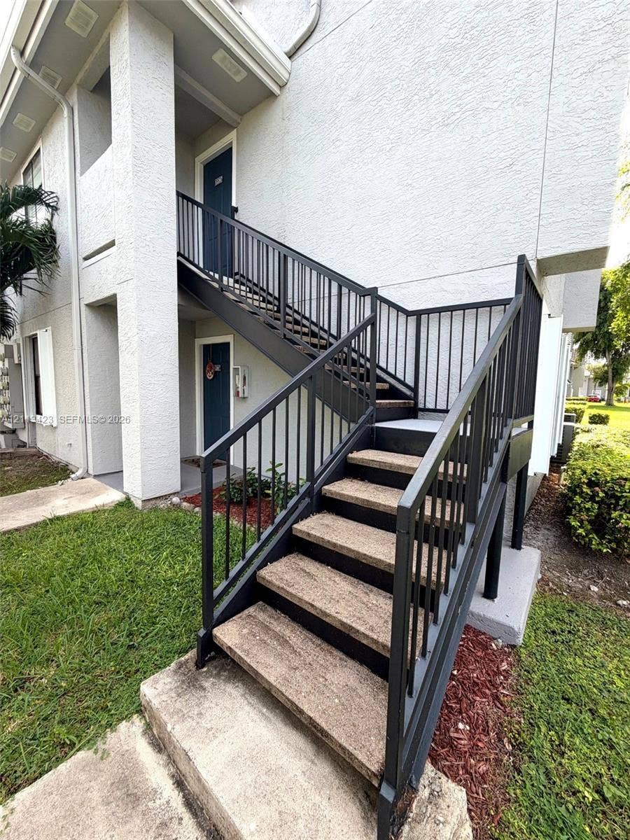 10360 SW 150th Court, #12207, Miami, Miami, FL 33196 Stucco exterior featuring external concrete stairs with black metal handrails and landings
