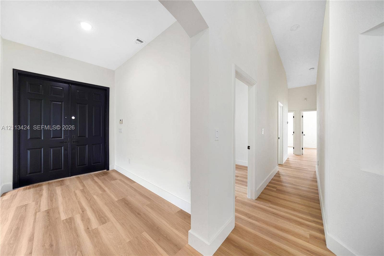 2465 SW 132nd Terrace, Miramar, FL 33027 Entryway featuring double black doors, high ceilings, wood-finish flooring, recessed lighting, and an arched architectural opening
