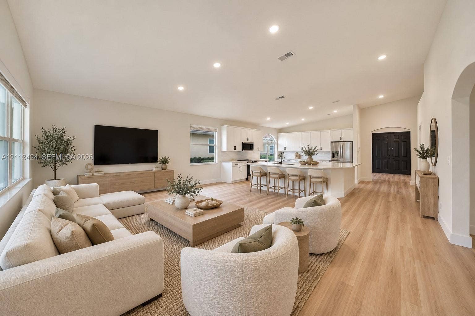 2465 SW 132nd Terrace, Miramar, FL 33027 virtually staged Open-concept interior featuring vaulted ceilings, wood-finish flooring, recessed lighting, and a kitchen island with stone countertops