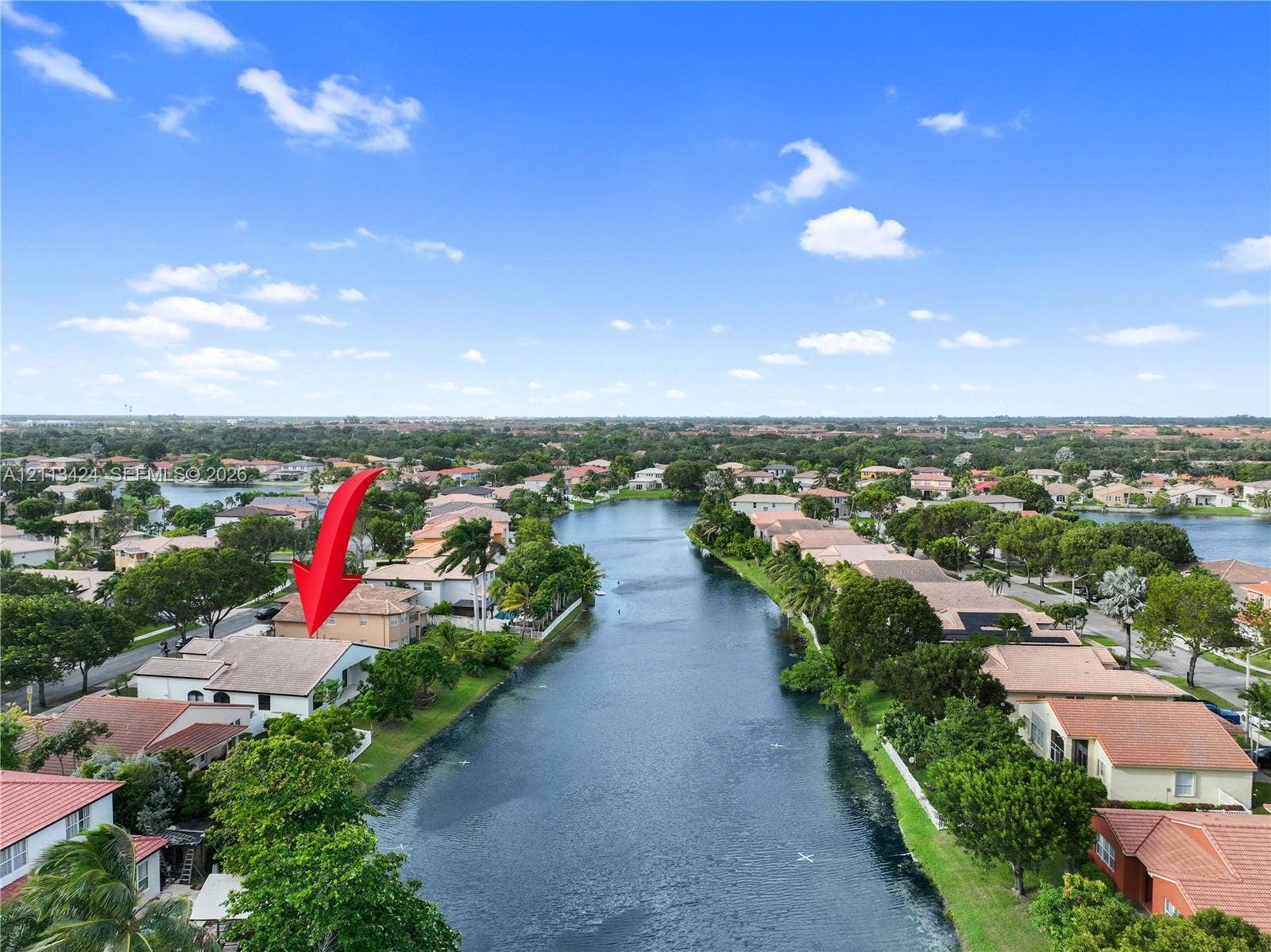 2465 SW 132nd Terrace, Miramar, FL 33027 Waterfront property featuring a tile roof, stucco exterior, and direct water access