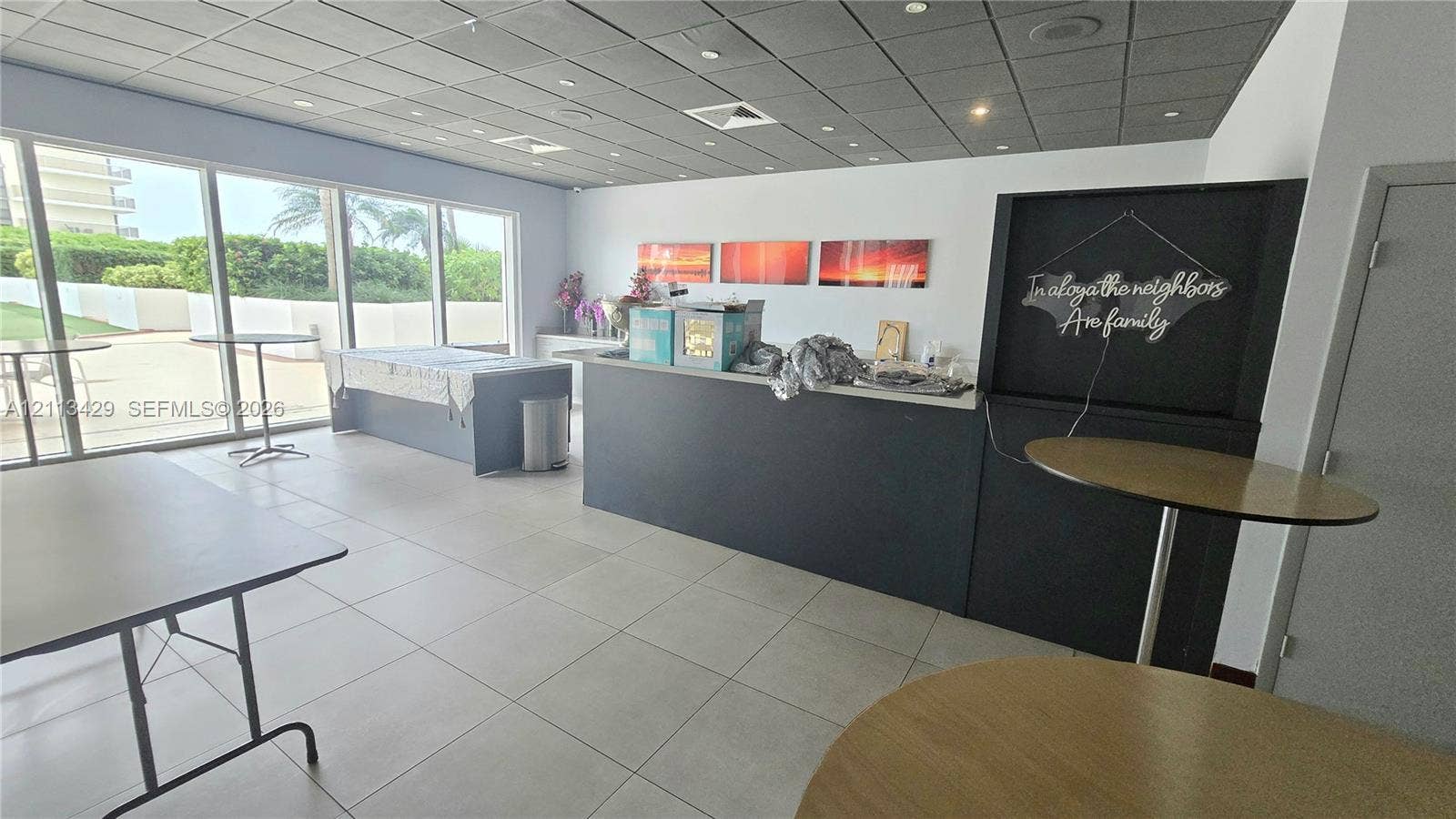 6365 Collins Avenue, #909, Miami Beach, FL 33141 Large-format tile flooring, expansive floor-to-ceiling windows, and built-in service counter with solid surface countertop