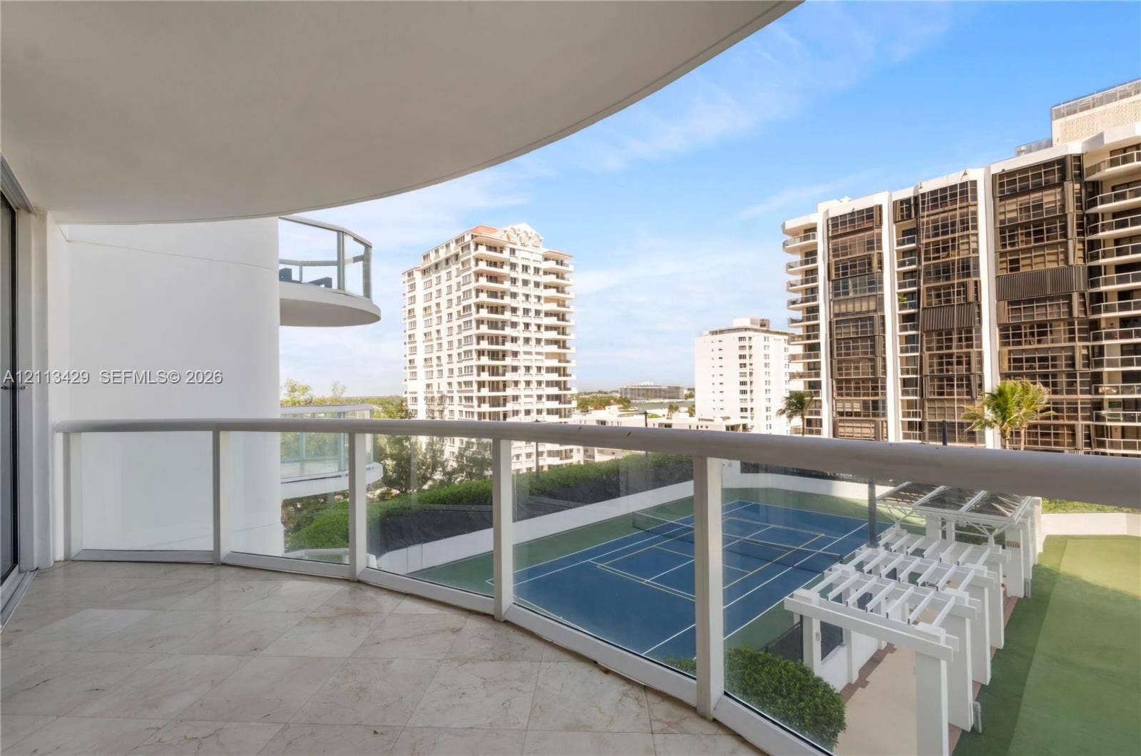 6365 Collins Avenue, #909, Miami Beach, FL 33141 Covered balcony featuring stone flooring and a glass-paneled railing
