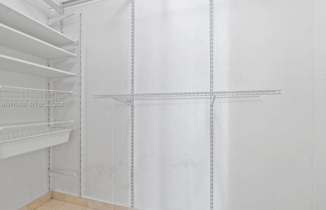 6365 Collins Avenue, #909, Miami Beach, FL 33141 Customizable white wire shelving system featuring tiered shelves, integrated wire baskets, and vertical adjustable track supports