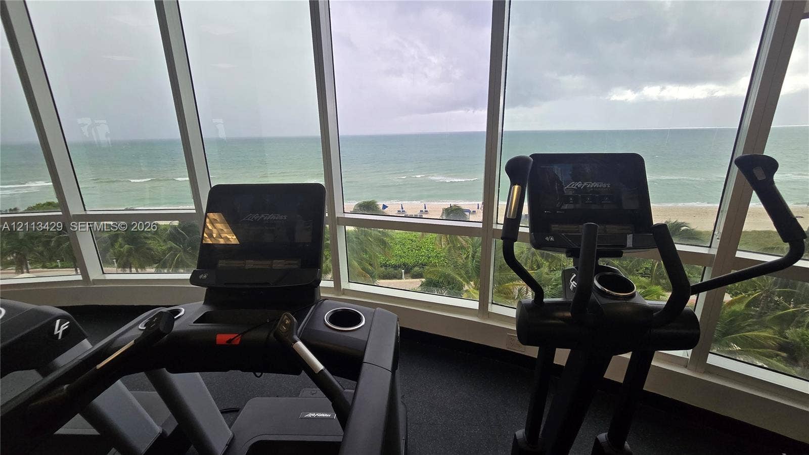 6365 Collins Avenue, #909, Miami Beach, FL 33141 Fitness center featuring floor-to-ceiling windows and coastal scenery