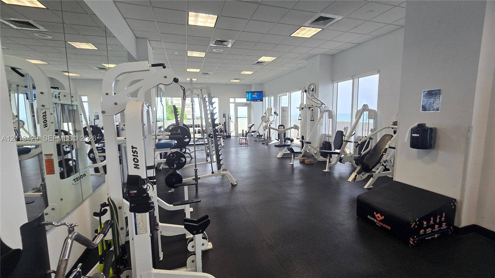 6365 Collins Avenue, #909, Miami Beach, FL 33141 Fitness center featuring rubber flooring, expansive wall-to-wall mirrors, recessed lighting, and large windows