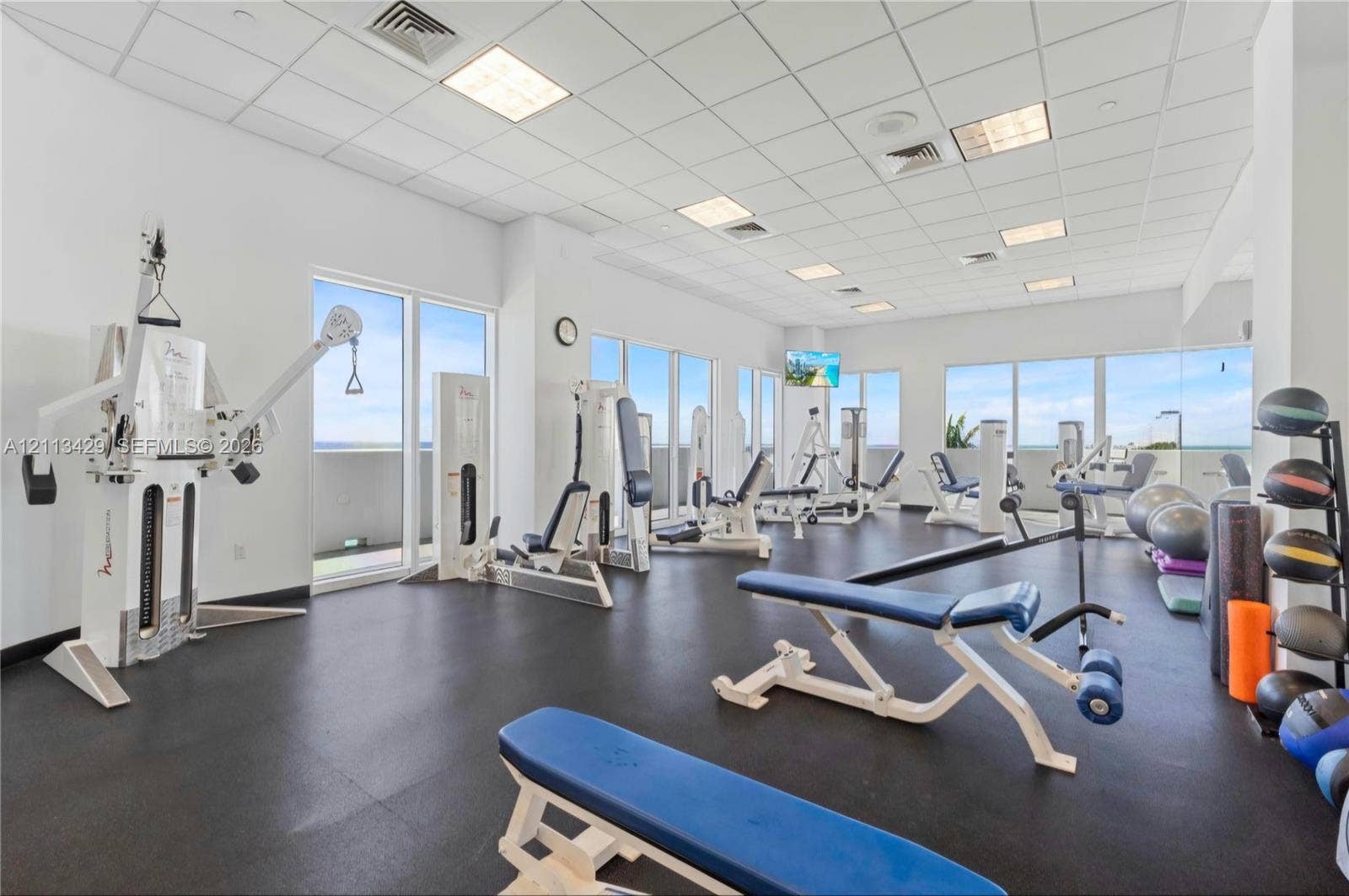 6365 Collins Avenue, #909, Miami Beach, FL 33141 Fitness center featuring rubber flooring, recessed drop ceiling lighting, and expansive floor-to-ceiling windows
