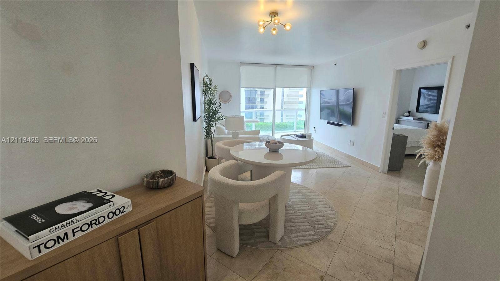 6365 Collins Avenue, #909, Miami Beach, FL 33141 Large-format tile flooring, multi-arm ceiling fixture, and sliding glass balcony doors