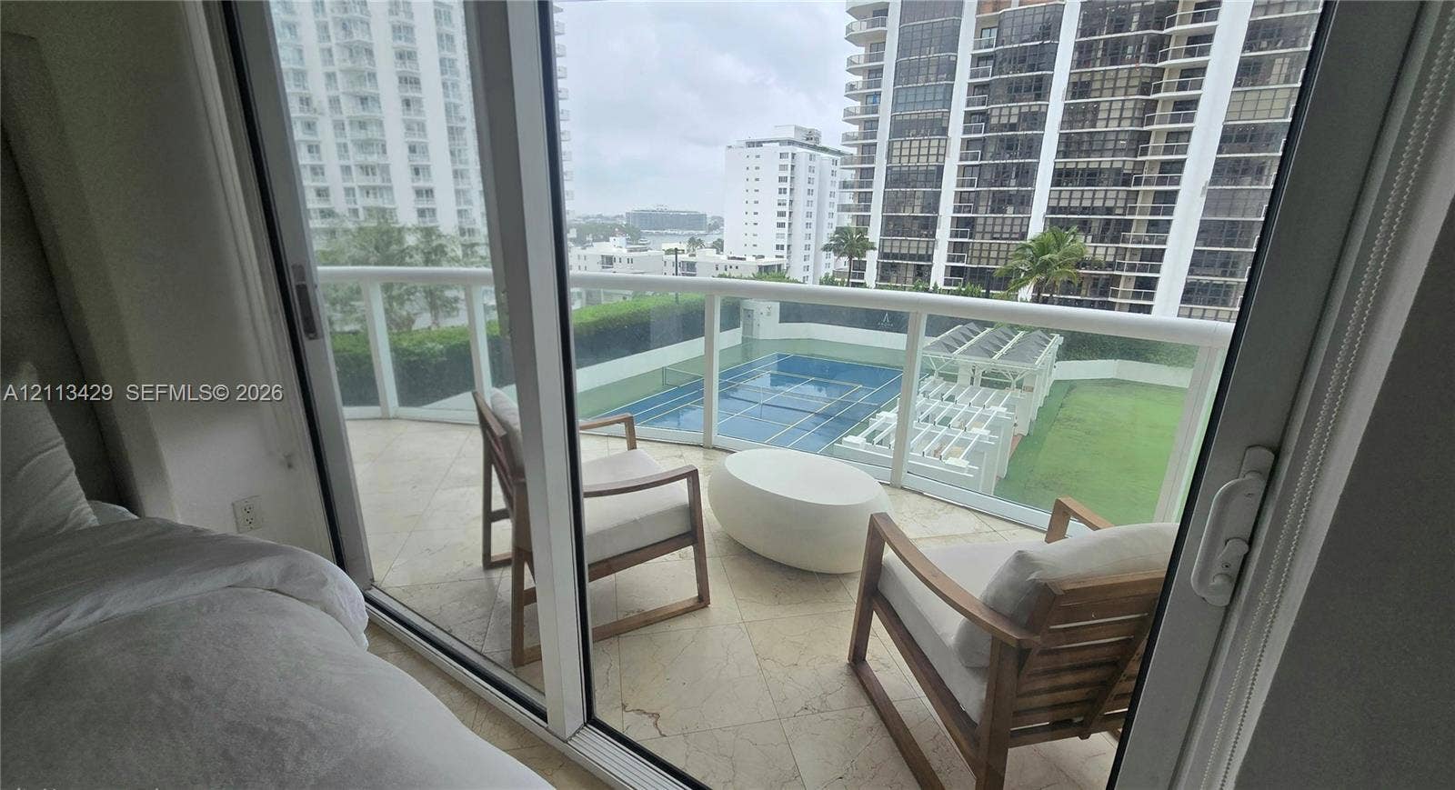 6365 Collins Avenue, #909, Miami Beach, FL 33141 Private balcony featuring stone tile flooring and a glass panel railing