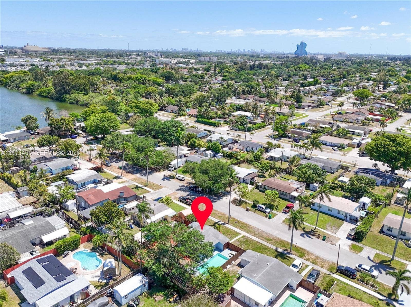 5621 SW 38th Court, Davie, Davie, FL 33314 Aerial view of the residential property featuring an in-ground swimming pool, privacy fencing, mature trees, and proximity to the canal