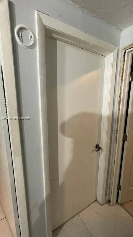 Solid core door featuring white painted finish, rectangular door casing, and metal lever handle hardware
