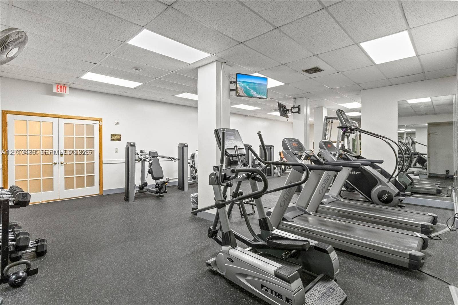 3800 S Ocean Drive, #416, Hollywood, FL 33019 Fitness center featuring rubber flooring, recessed drop-ceiling lighting, full-wall mirrors, and double French doors