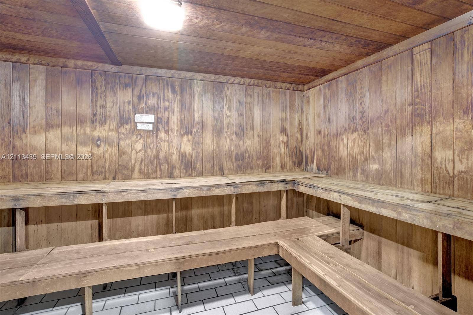3800 S Ocean Drive, #416, Hollywood, FL 33019 Sauna featuring wood-paneled walls and ceiling, multi-level built-in wood bench seating, and tile flooring
