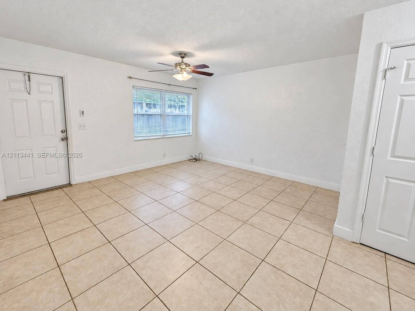 80 NE 36th Court, #82, Oakland Park, Oakland Park, FL 33334 Interior space featuring ceramic tile flooring, a multi-pane window, and a central ceiling fan with integrated lighting
