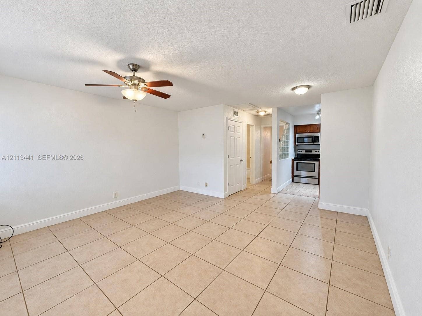 80 NE 36th Court, #82, Oakland Park, Oakland Park, FL 33334 Open-concept interior featuring large-format neutral tile flooring, ceiling fan with integrated light fixture, recessed lighting, and kitchen equipped with stainless steel appliances