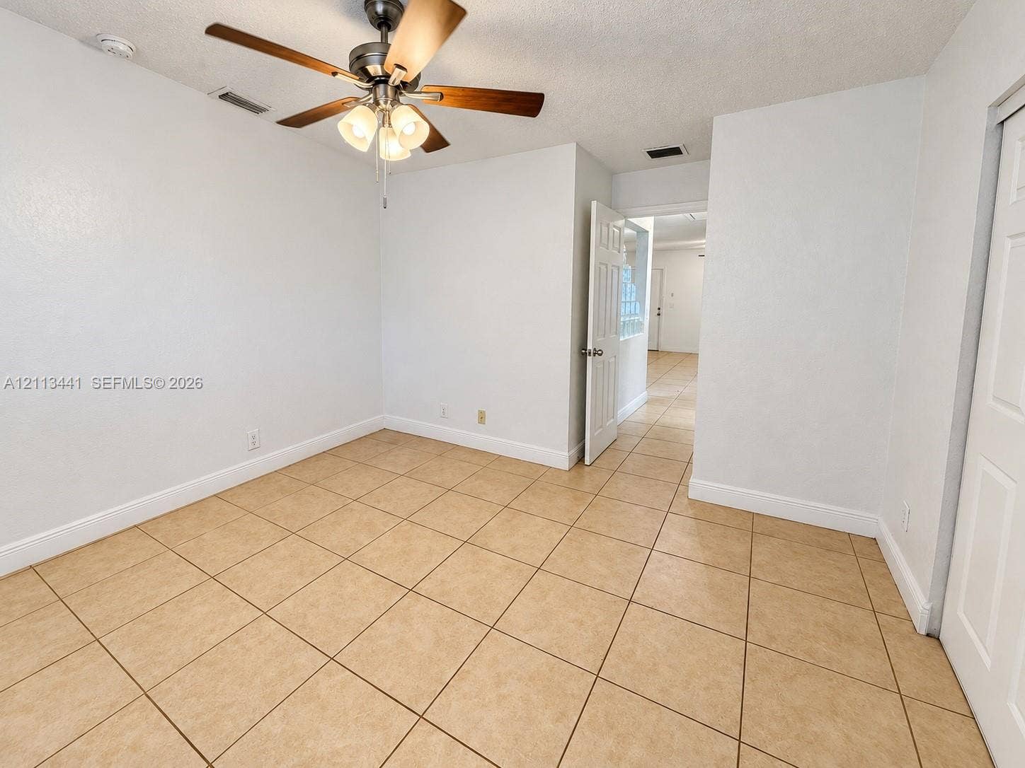 80 NE 36th Court, #82, Oakland Park, Oakland Park, FL 33334 Neutral-toned ceramic tile flooring, ceiling fan with integrated three-light fixture, and white panel doors