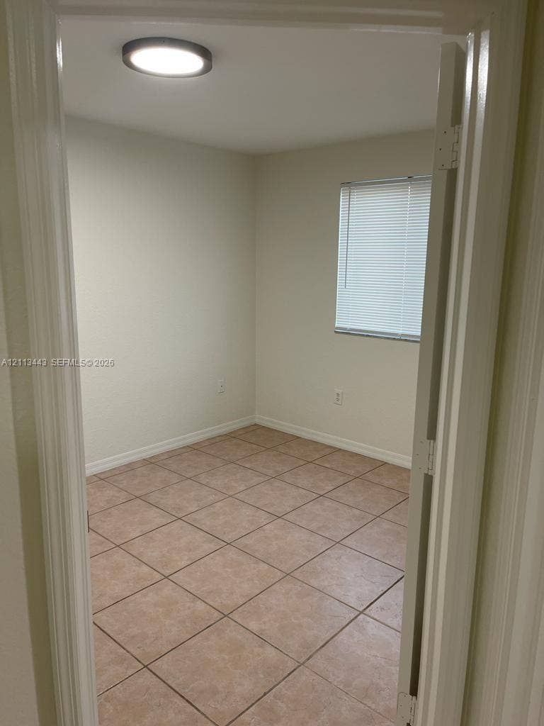 5705 NW 109th Avenue, #47, Doral, Doral, FL 33178 Neutral-toned walls, tile flooring, flush-mount ceiling lighting, and window with horizontal blinds