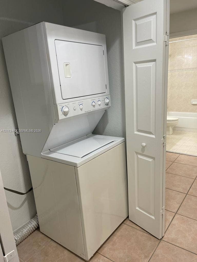 5705 NW 109th Avenue, #47, Doral, Doral, FL 33178 Stackable white top-load washer and dryer unit with white bi-fold closet door and tile flooring