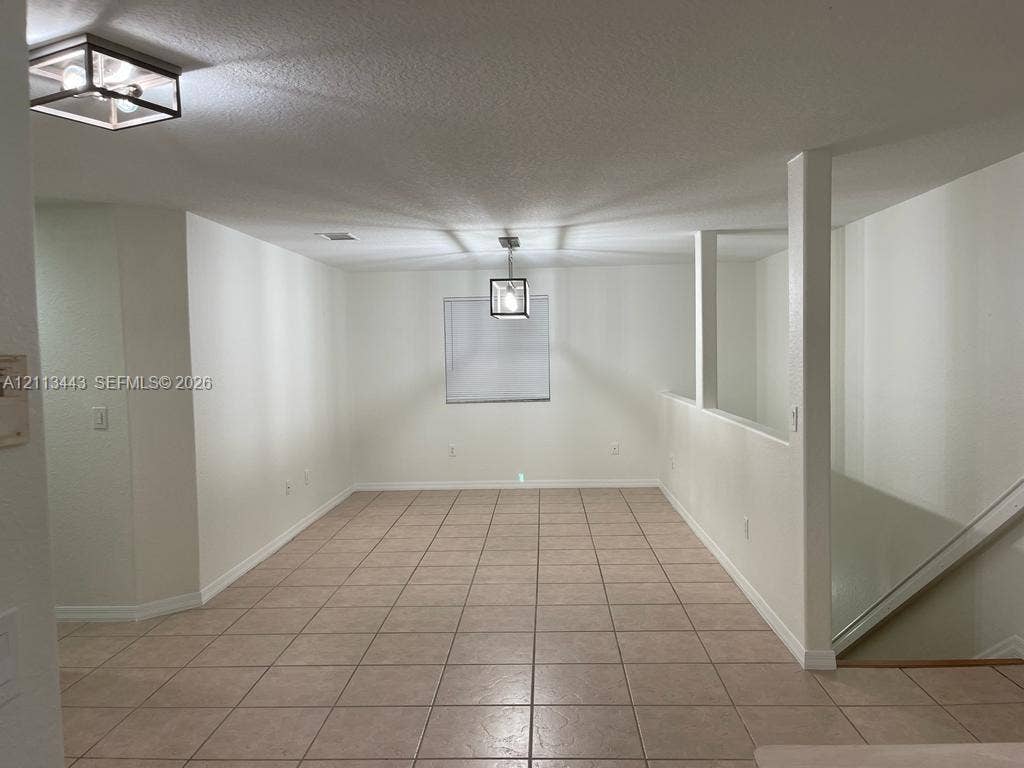 5705 NW 109th Avenue, #47, Doral, Doral, FL 33178 Neutral tile flooring, dual geometric glass-paneled light fixtures, and structural half-wall detailing