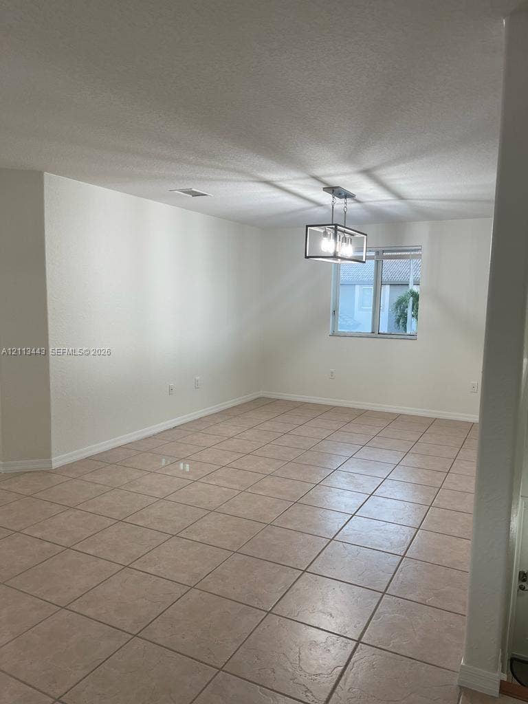 5705 NW 109th Avenue, #47, Doral, Doral, FL 33178 Neutral-toned ceramic tile flooring, rectangular window, and a geometric metal frame light fixture
